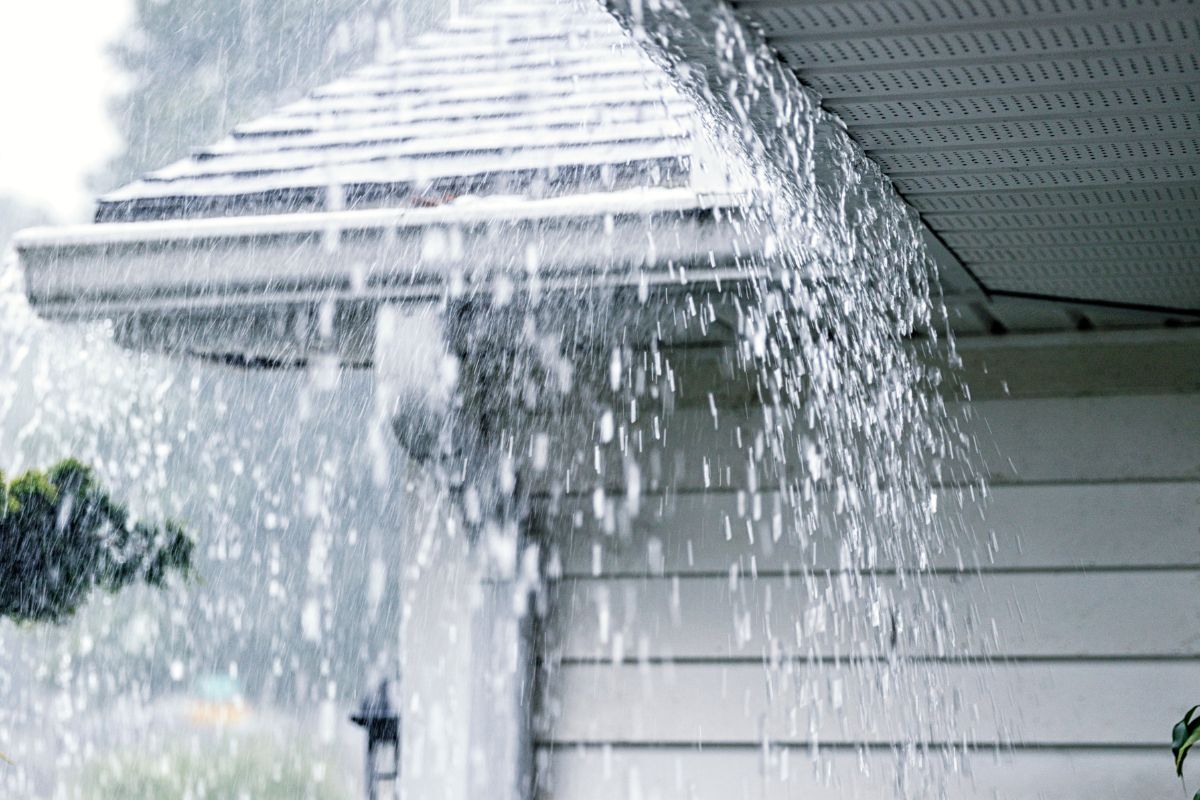 water overflowing onto the roof and siding.