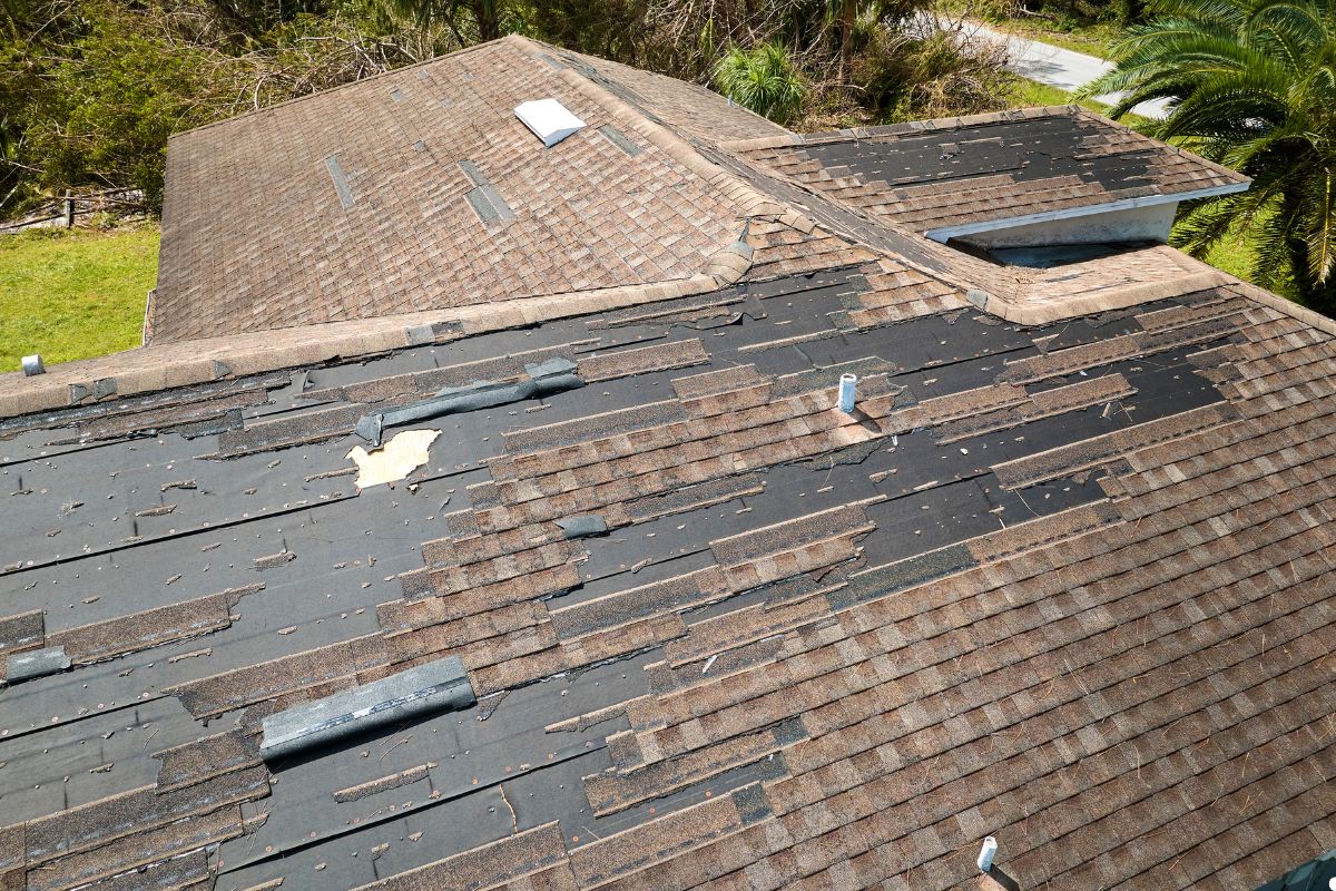 Roofing repair service in Tampa, Florida, showcasing workers fixing a residential roof under a clear blue sky. 