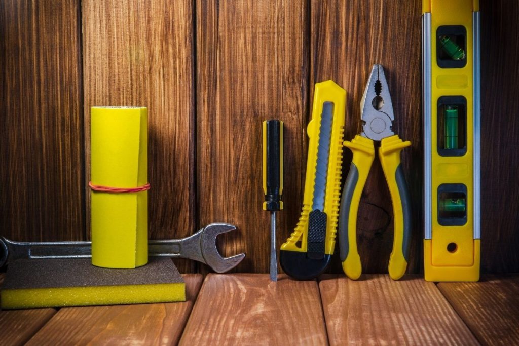 A variety of tools arranged on a wooden surface, with ample copy space for text above them.