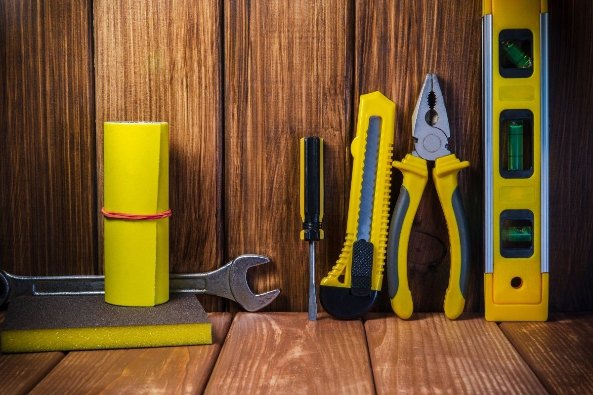 A variety of tools arranged on a wooden surface, with ample copy space for text above them.